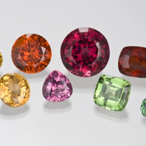 Photographed from the GIA Collection for the CIBJO project. Top row, left to right: 16.94 ct yellow oval garnet; 19.89 ct round orange spessartite garnet; 44.28 ct round, deep pink rhodolite garnet; 16.99 ct reddish orange cushion cut garnet; and 7.26 ct cushion cut tsavorite garnet. Bottom row, left to right: 8.20 ct oval greenish yellow garnet; 12.36 ct oval golden yellow garnet; 9.22 ct pink pear cut garnet; 14.53 ct light green cushion cut grossular garnet and 4.32 ct bluish green cushion cut garnet.